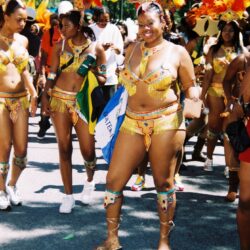 Carnival dancers in colorful feathered costumes.