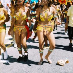Carnival dancers in colorful feathered costumes.
