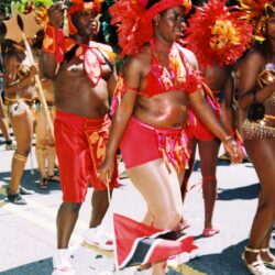 Carnival dancers in colorful costumes and flags.