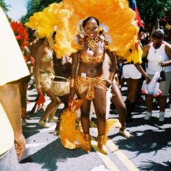 Carnival dancer in vibrant orange costume.