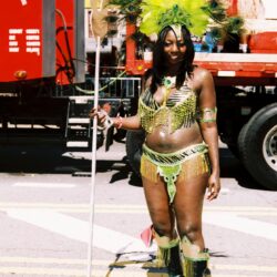 Carnival performer in colorful feathered costume.
