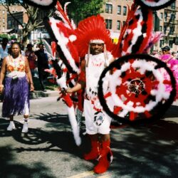 Carnival performer in vibrant red and white costume.