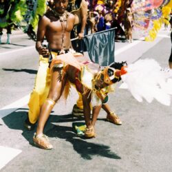 Carnival performers dancing in vibrant costumes outdoors.