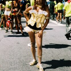 Person in gold costume at outdoor event.