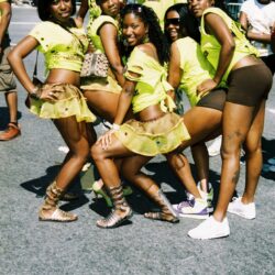 Group posing in bright festival outfits outdoors.