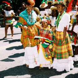 People in colorful traditional costumes at parade.