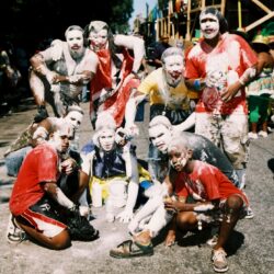 Group celebrating with painted faces outdoors.