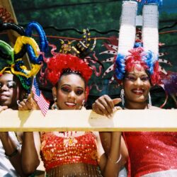 Three people with colorful, elaborate hairstyles.