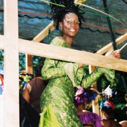 Woman in green costume smiling at parade.