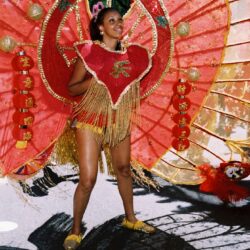Carnival dancer in vibrant red and gold.