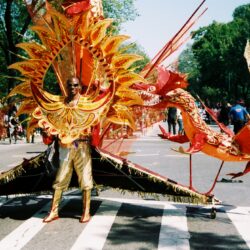 Person in elaborate dragon costume at parade.