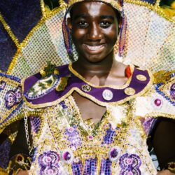 Smiling person in ornate purple carnival costume