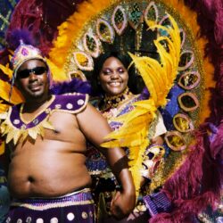 Two people in colorful feathered carnival costumes