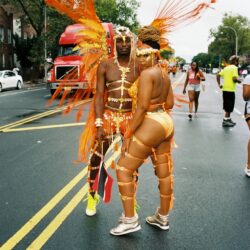 Carnival dancers in vibrant orange costumes.