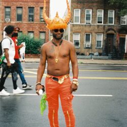Man wearing lobster hat in street.