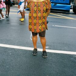 Person wearing colorful outfit on a street.