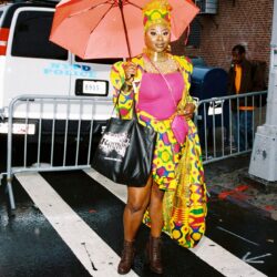 Person in colorful outfit with umbrella.