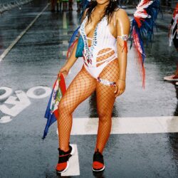 Carnival attendee in vibrant feathered costume.