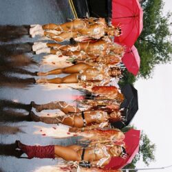 Carnival dancers in colorful costumes with umbrellas.