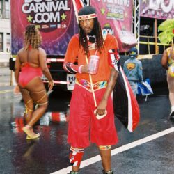 Carnival performer in vibrant red costume.