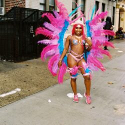 Person in colorful carnival costume on street.