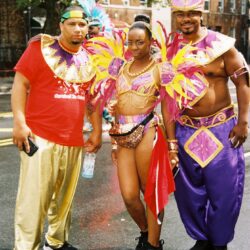 Carnival participants wearing colorful costumes outdoors.