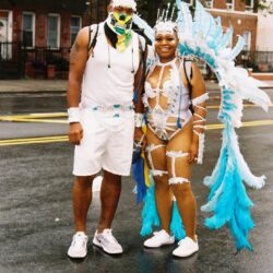 People in colorful carnival costumes on street.