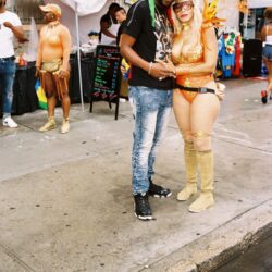 Couple in colorful costumes at street festival.