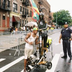 Man with statue on urban street.