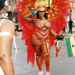 Carnival performer in vibrant red feather costume.