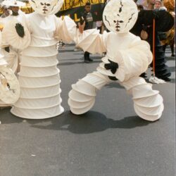 Parade performers in white spiral accordion costumes