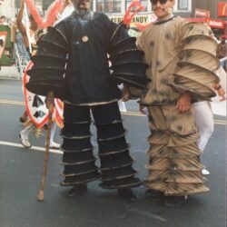 Two people in layered accordion-style parade costumes