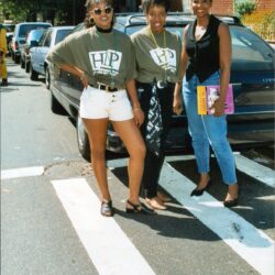 Three young women posing on street crosswalk