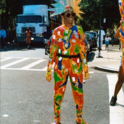 Person in colorful suit with sunburst crown