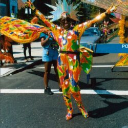 Parade participant wearing colorful sun costume