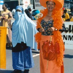 Two women in colorful parade costumes