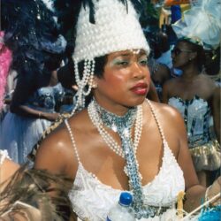 Carnival dancer in white beaded headdress holding water