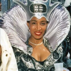 Person in ornate silver carnival costume smiling