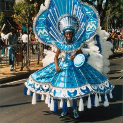 Parade performer in large blue headdress and costume