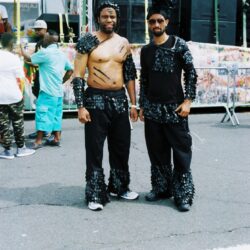 Two men in black feathered carnival costumes