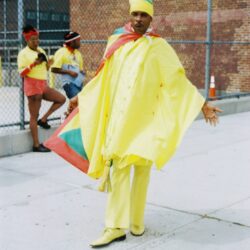 Person wearing yellow outfit with colorful cape