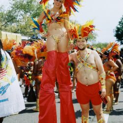 Stilt-walker and companion in vibrant carnival costumes