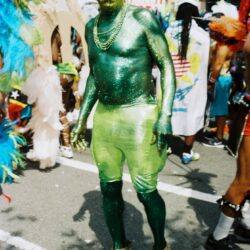 Green-painted man in carnival costume with sunglasses