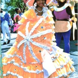 Person in orange ruffled parade costume and hat